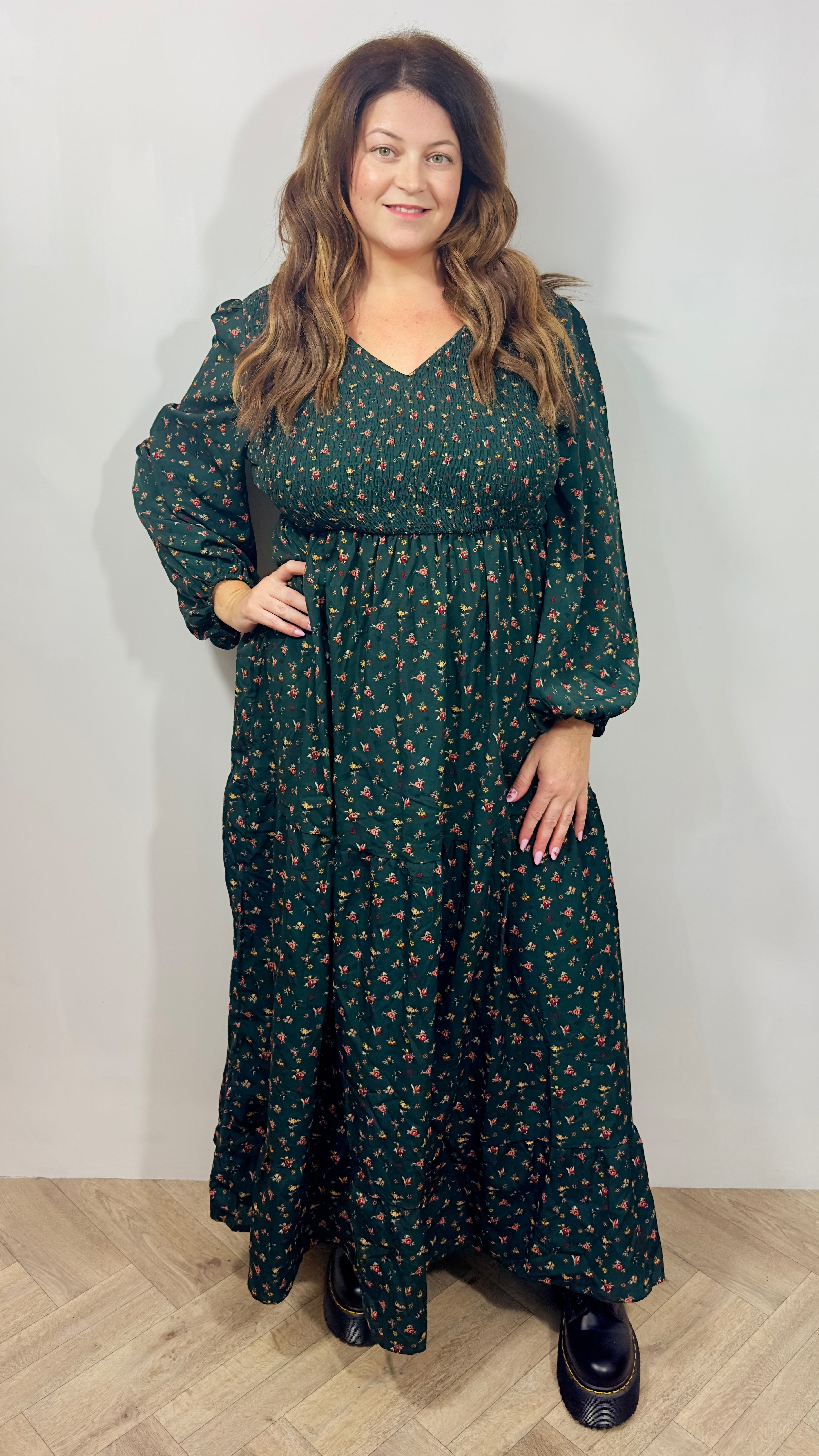 Woman wearing a green floral dress against a white background