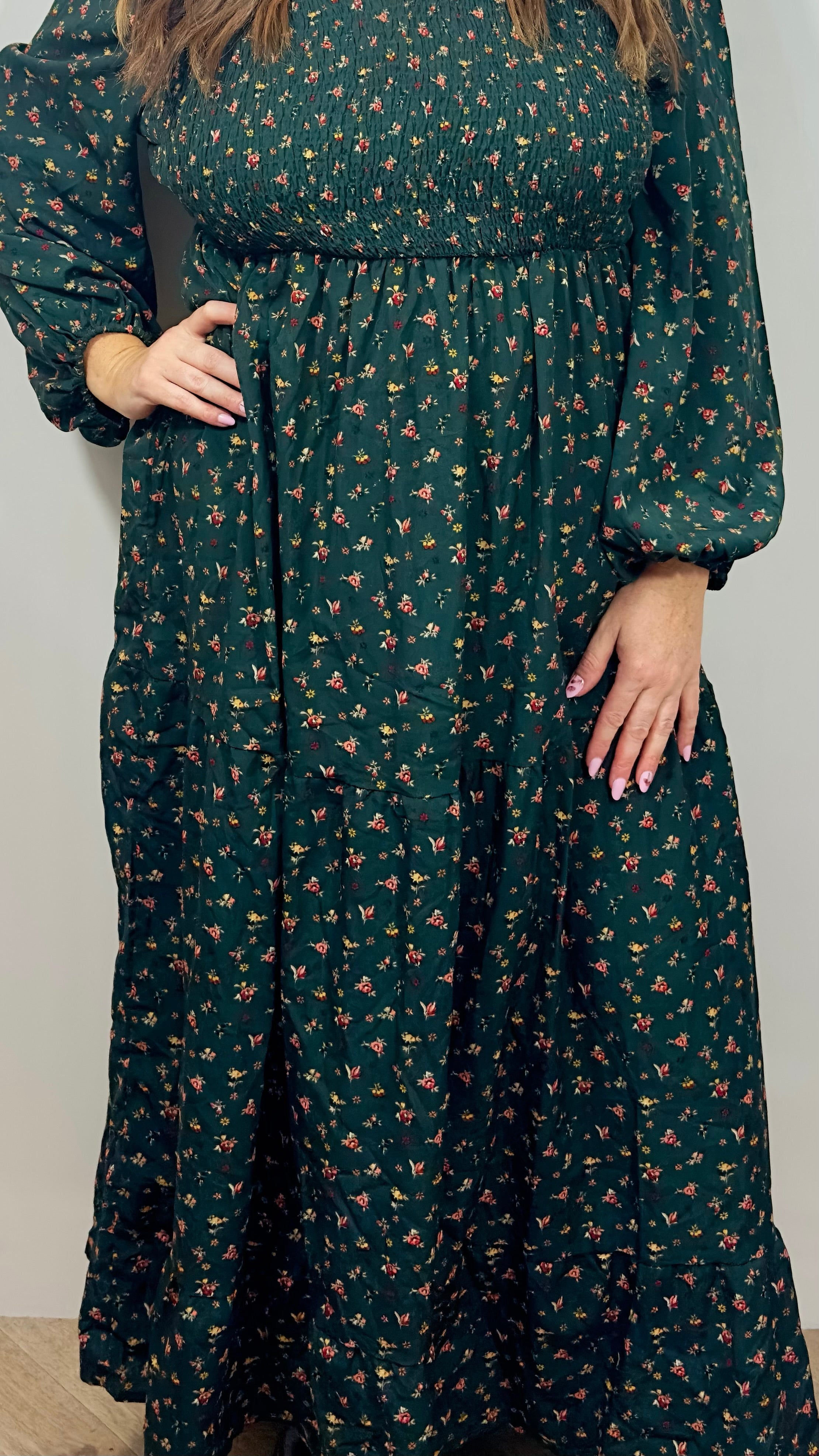 Green floral dress worn by a person against a plain background