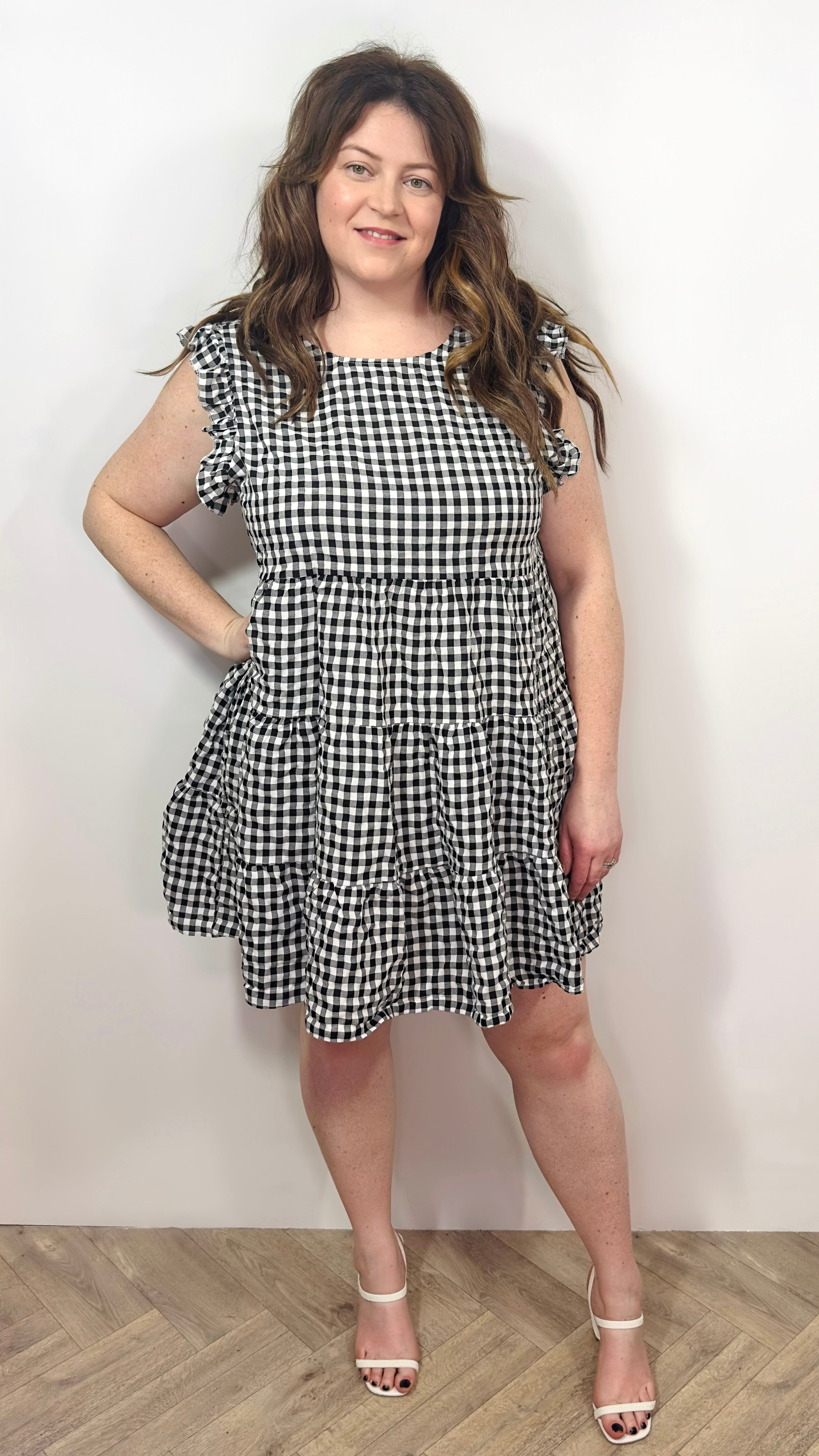 Woman wearing a black and white checkered dress against a plain background