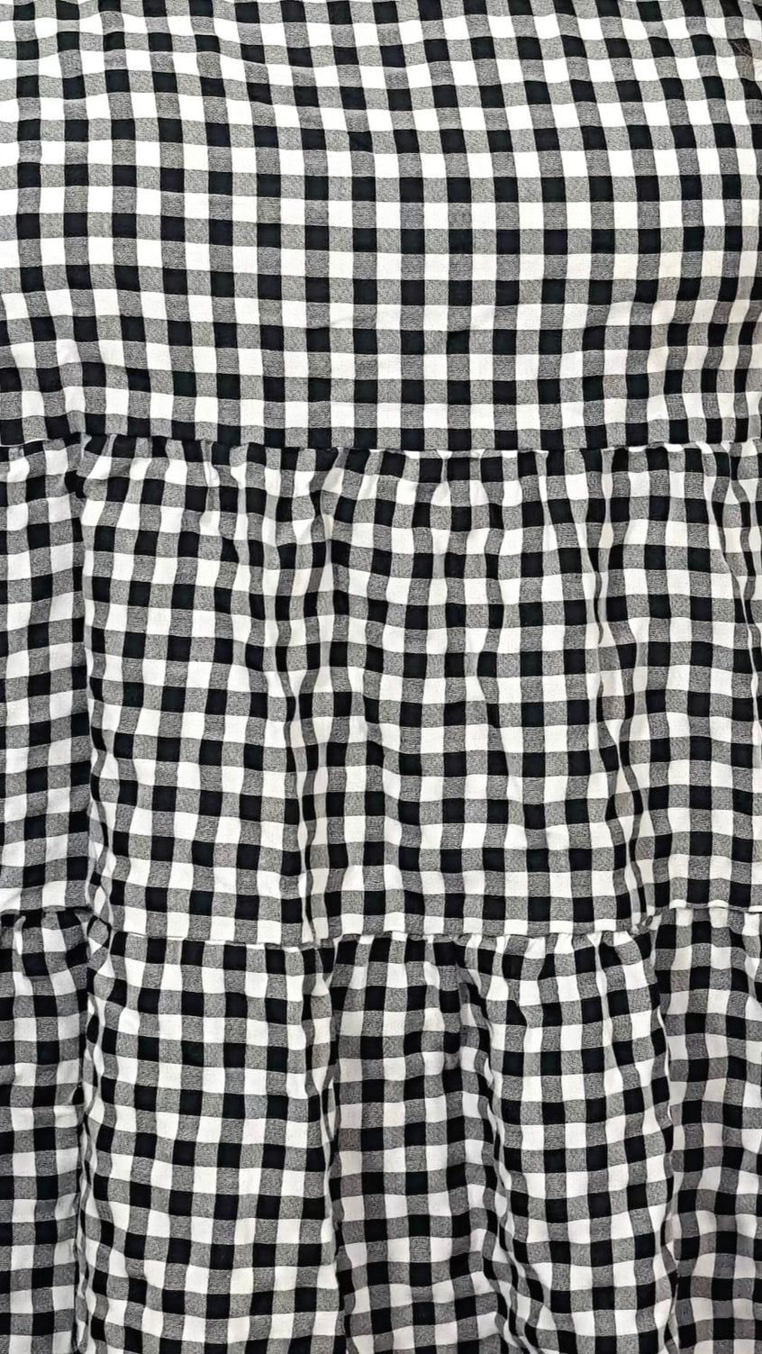 black and white checkered dress against a plain background