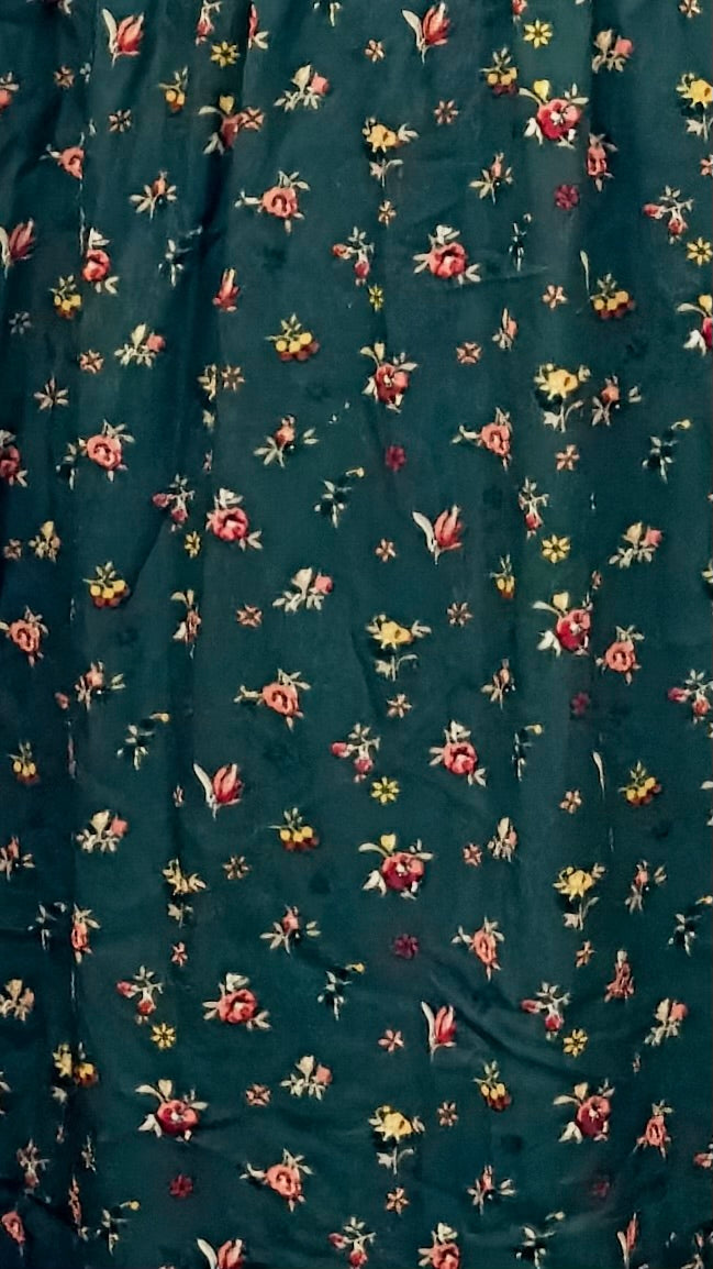 Floral patterned fabric with small flowers on a dark green background