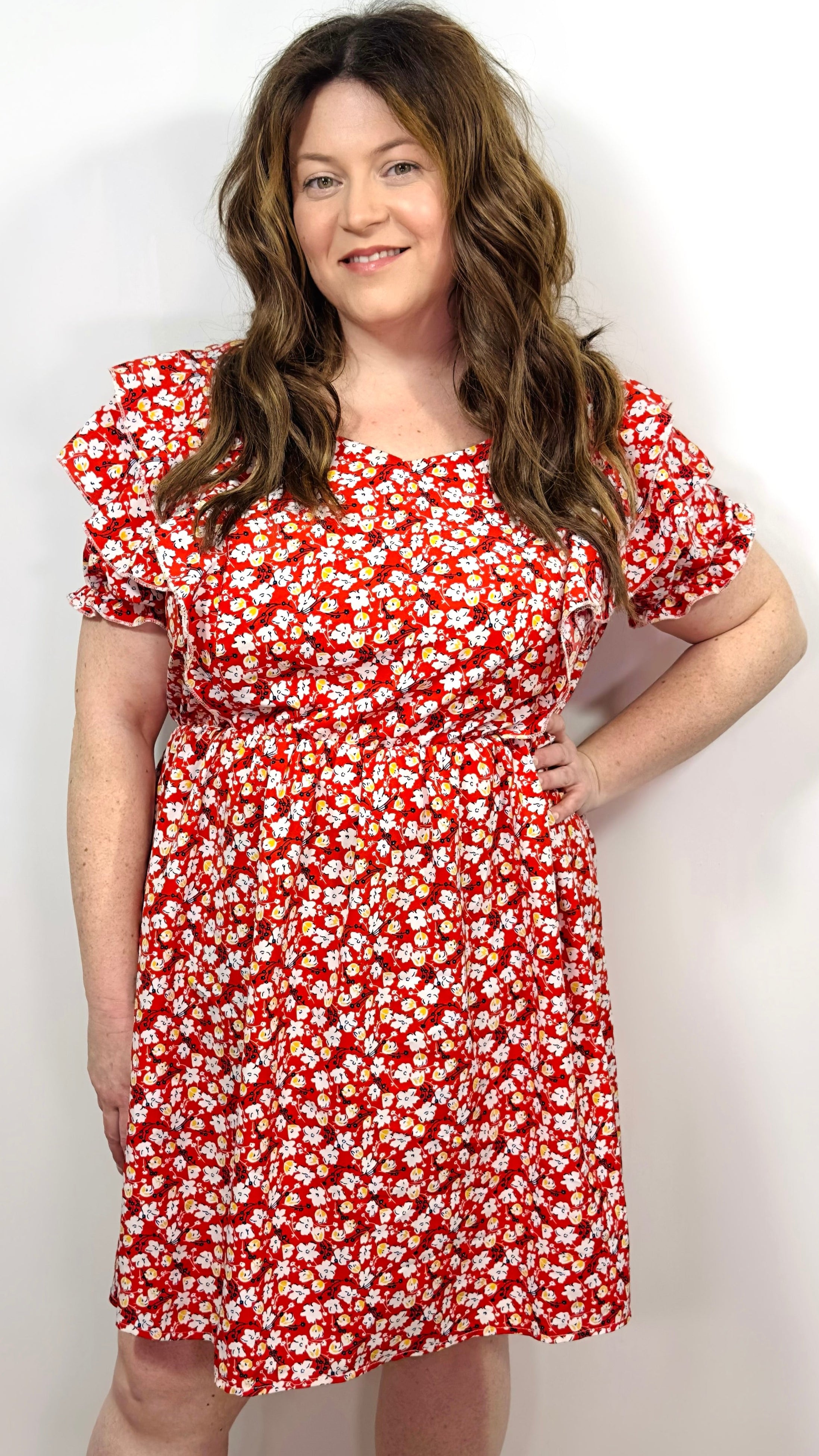 Woman wearing a red floral dress against a white background