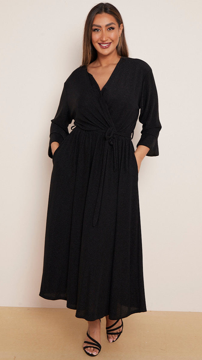 a woman wearing a black wrap dress with a white background