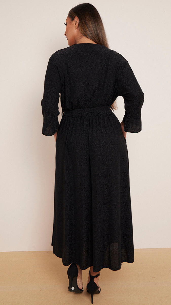 a woman wearing a black wrap dress with a white background
