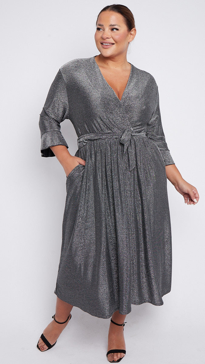 Woman wearing a silver wrap dress on a white background