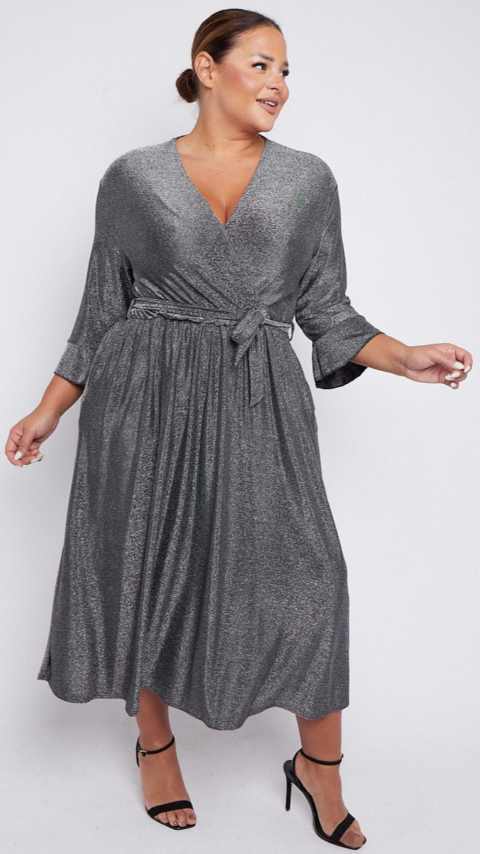 Woman wearing a silver wrap dress on a white background