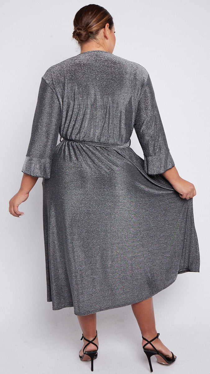 Woman wearing a silver wrap dress on a white background